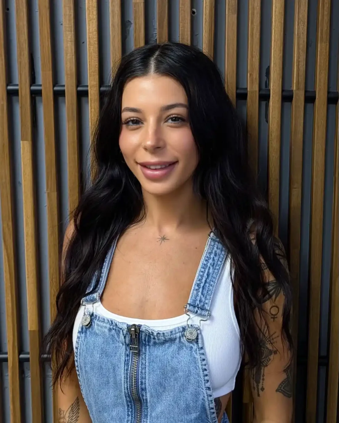 Lou standing in front of a wooden background.