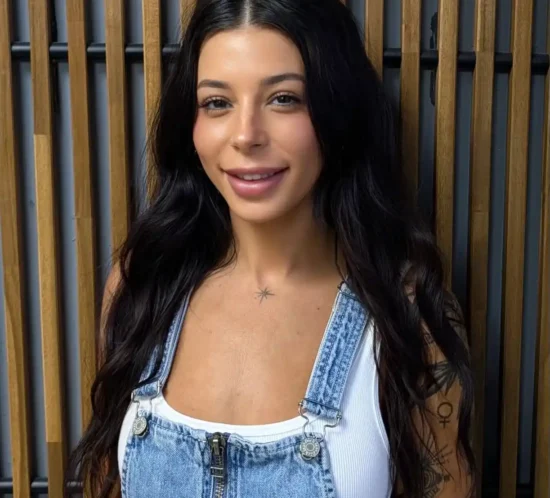 Lou standing in front of a wooden background.