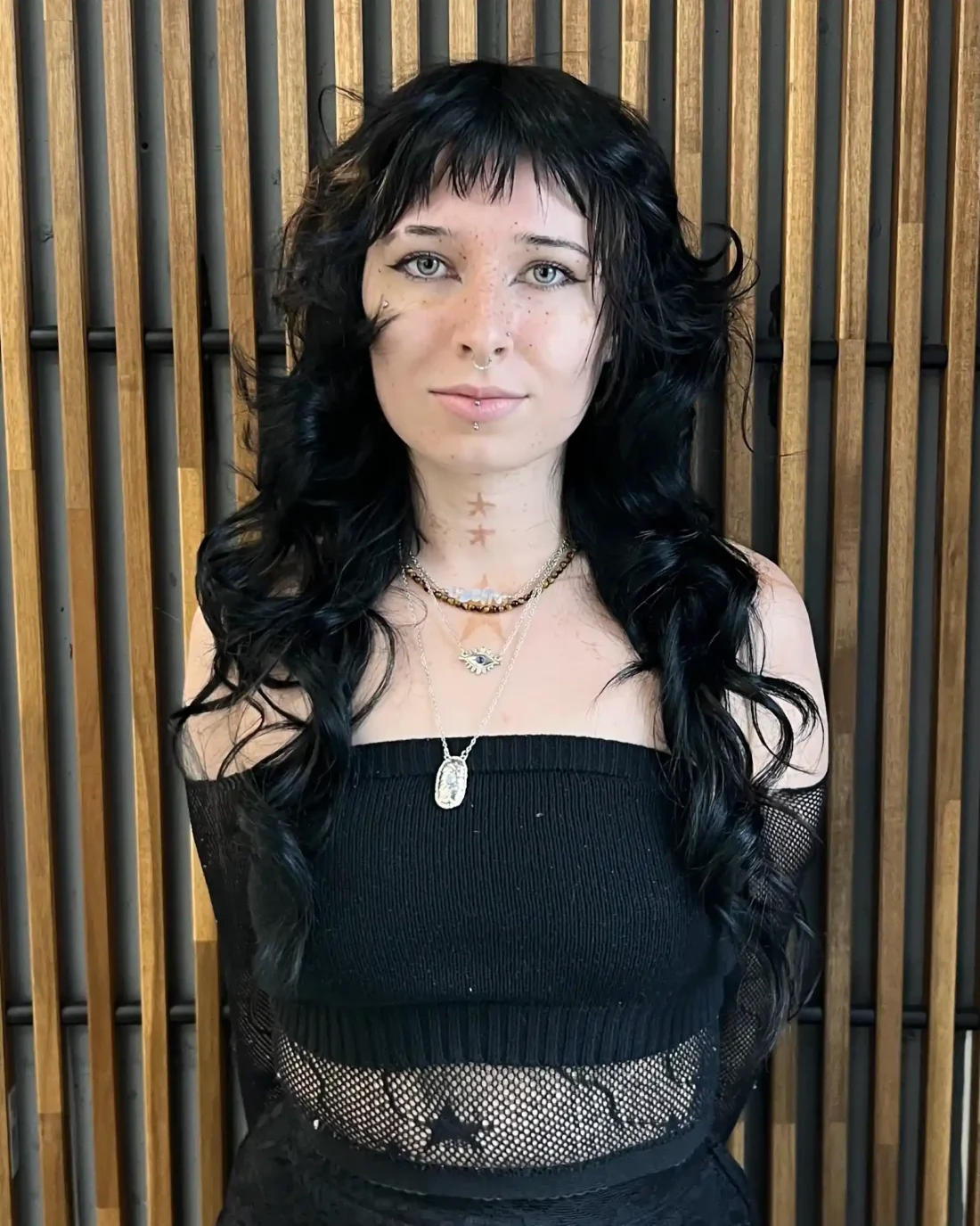 Starie standing in front of a wooden background.
