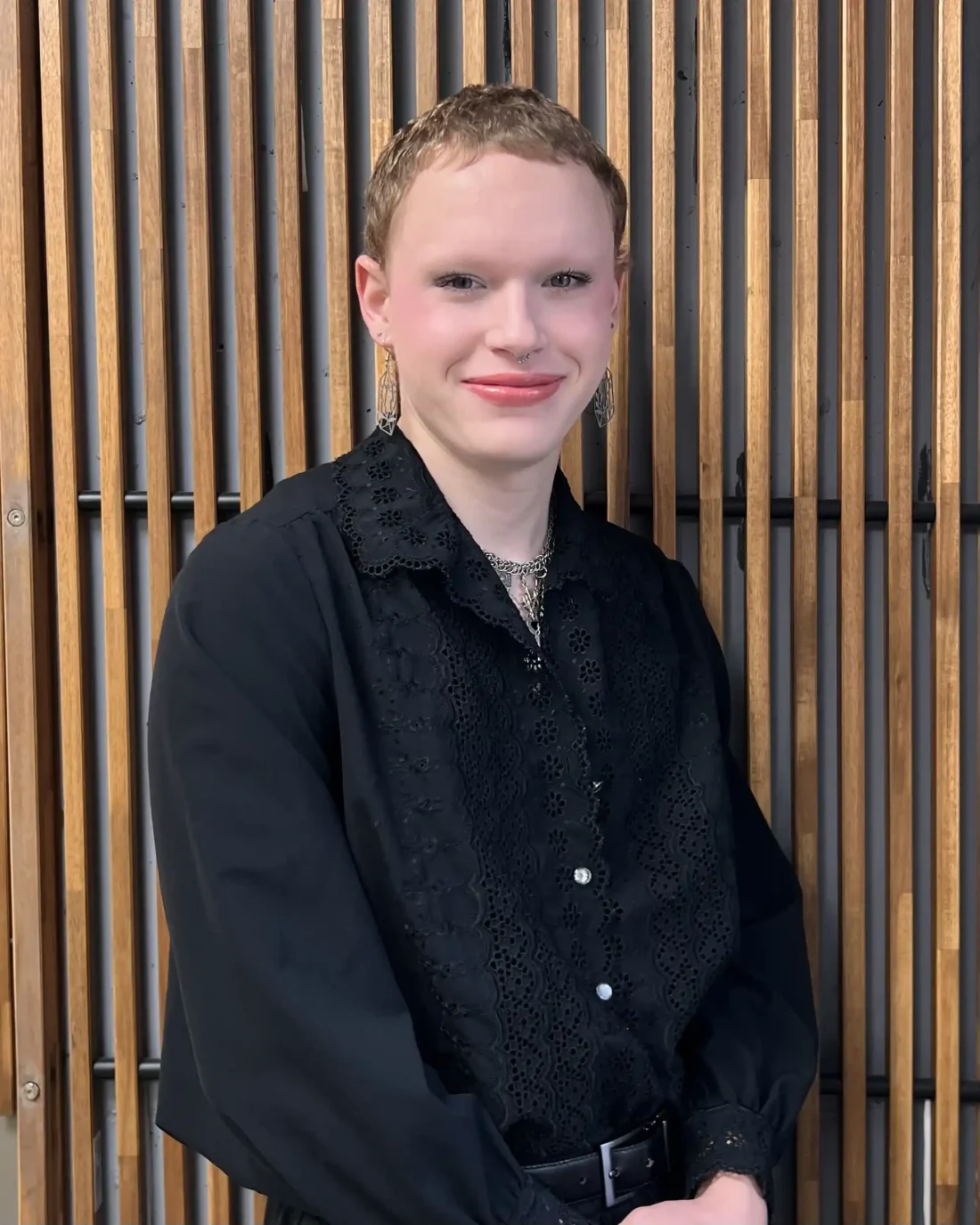 James standing in front of a wooden background.