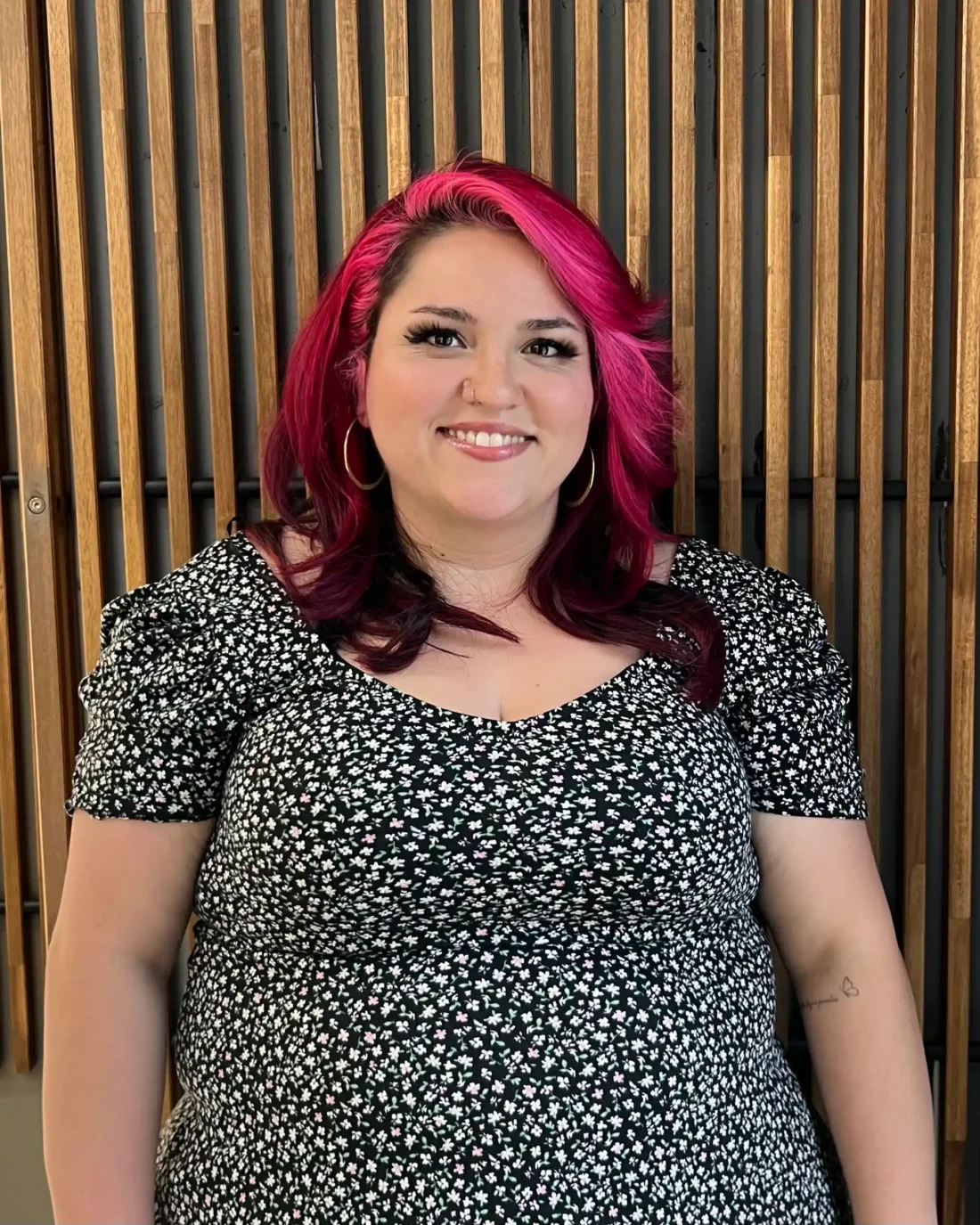 Sam standing in front of a wooden background.